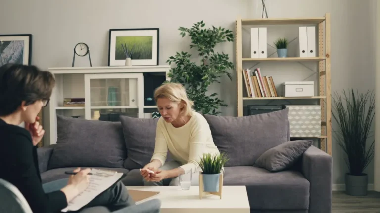 A woman consults with a therapist in a modern, cozy home setting, focusing on mental health.