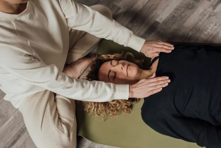 A woman receiving a holistic healing session indoors, focusing on relaxation and spiritual wellbeing.