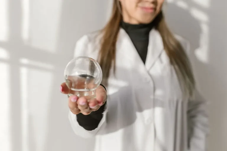 Close-up of a therapist holding a glass cupping tool, highlighting its use in alternative medicine.